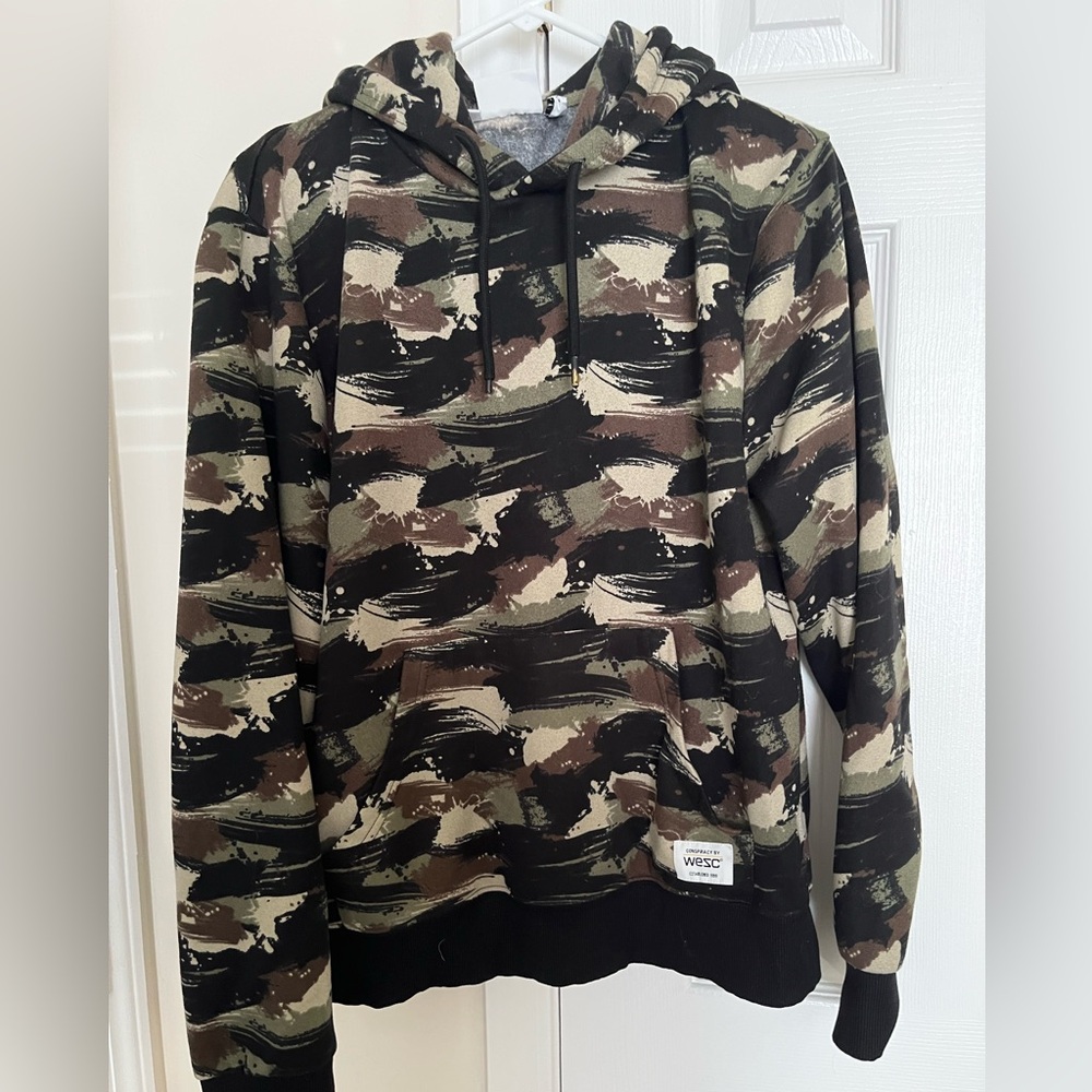 Conspiracy by WESC unisex camo hooded sweatshirt.